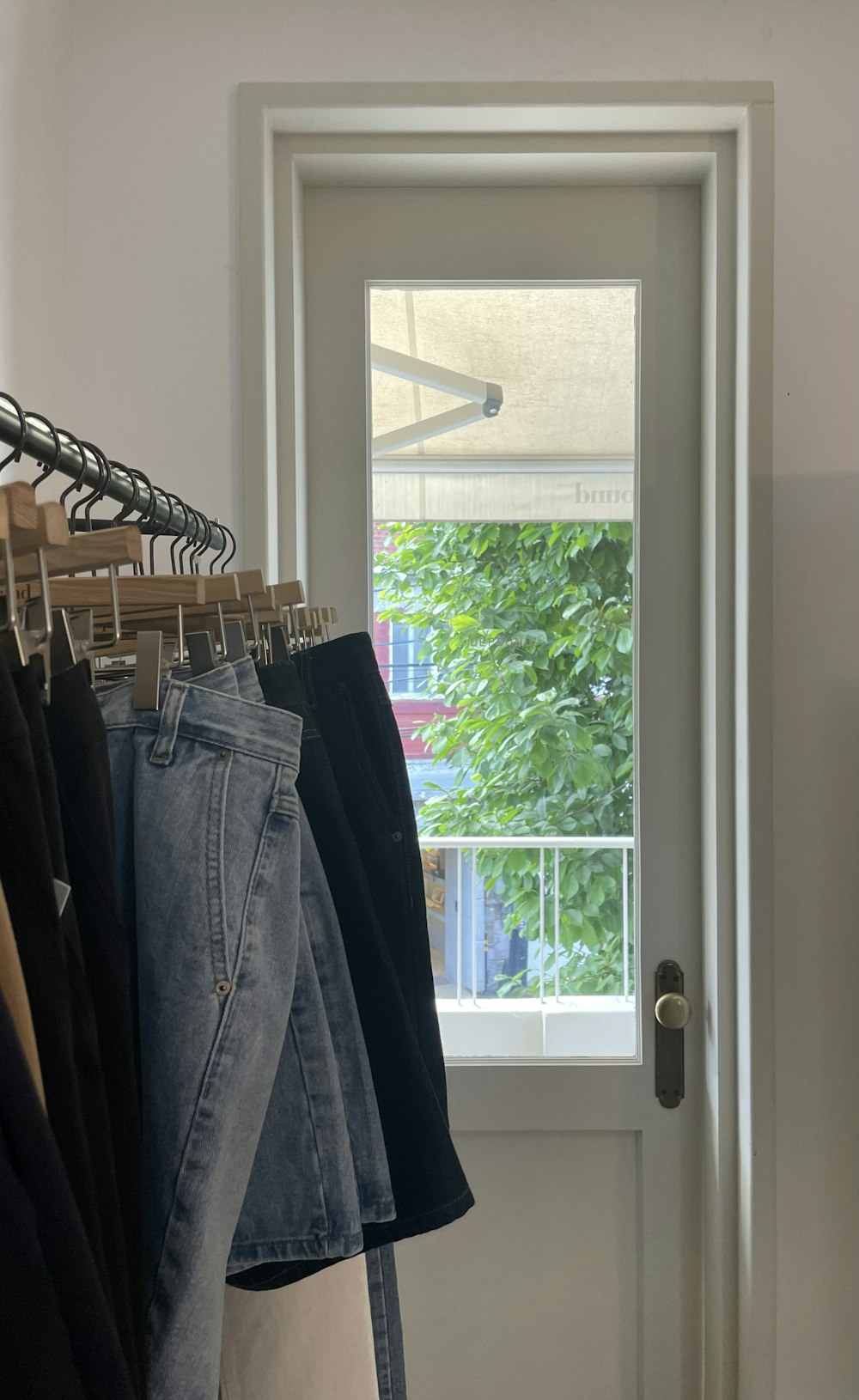 clothes hanging on a rail in front of a window