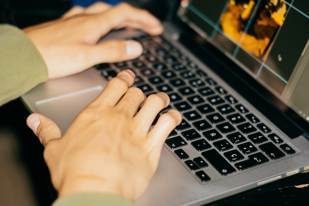 a person is typing on a laptop computer