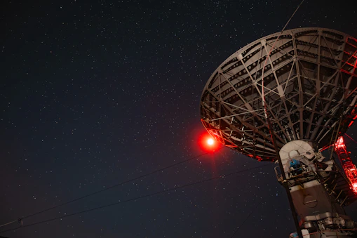 Close-up of a modern satellite communication system with glowing blue and amber lights