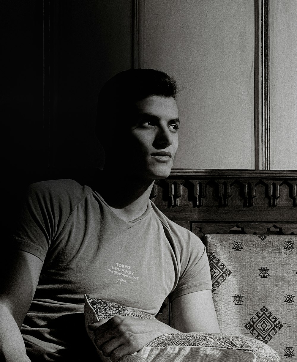 a black and white photo of a man sitting on a couch