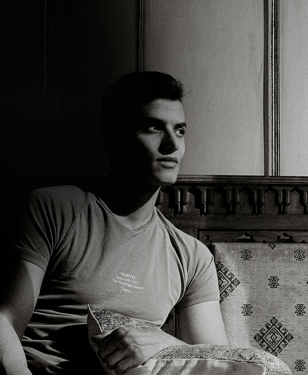 Ein Schwarz-Weiß-Foto eines Mannes, der auf einer Couch sitzt