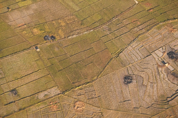 Aerial view of diverse land parcels with a team discussing plans around a table.