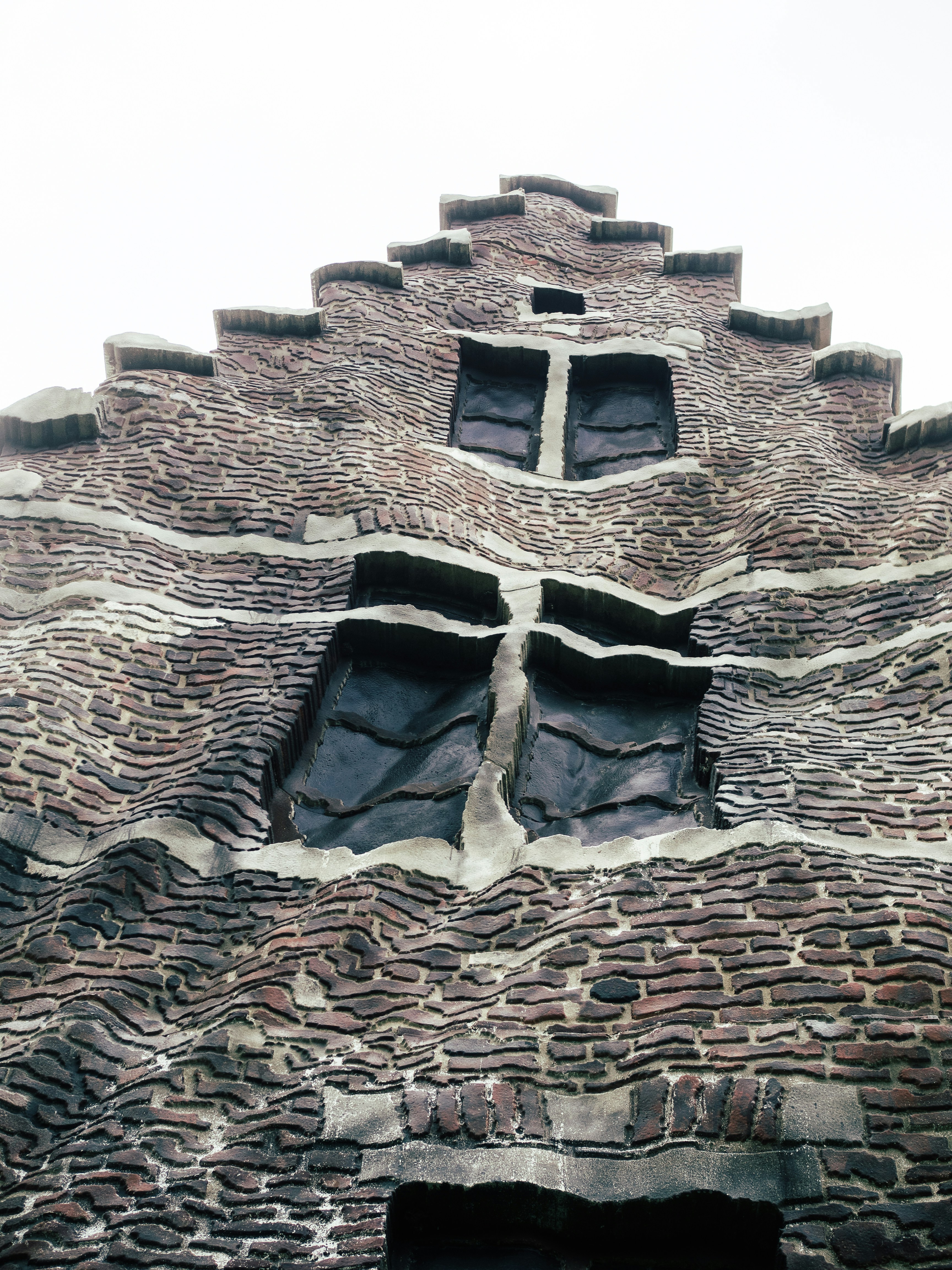 Un edificio de ladrillo muy alto con dos ventanas