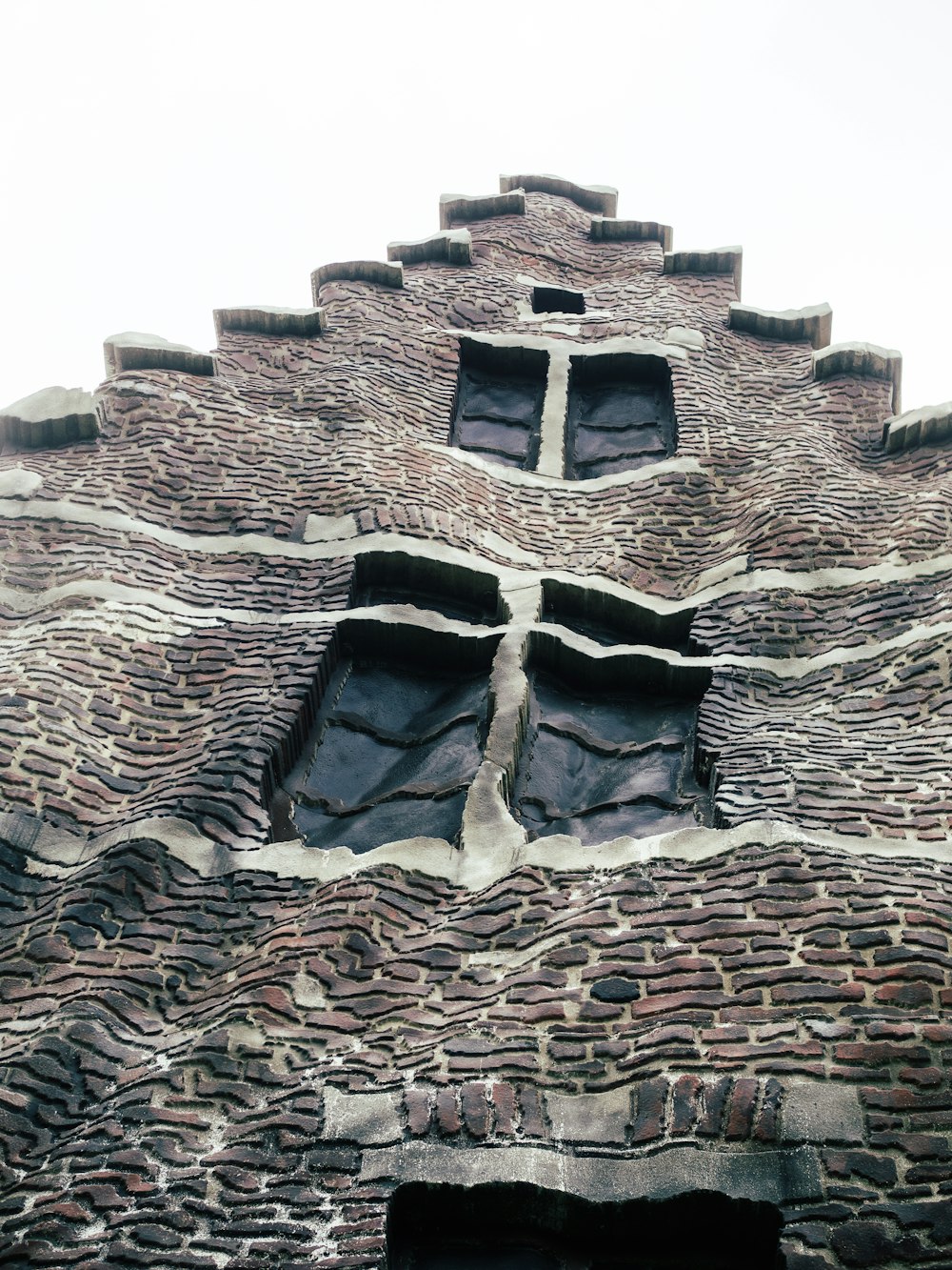 un très haut bâtiment en brique avec deux fenêtres