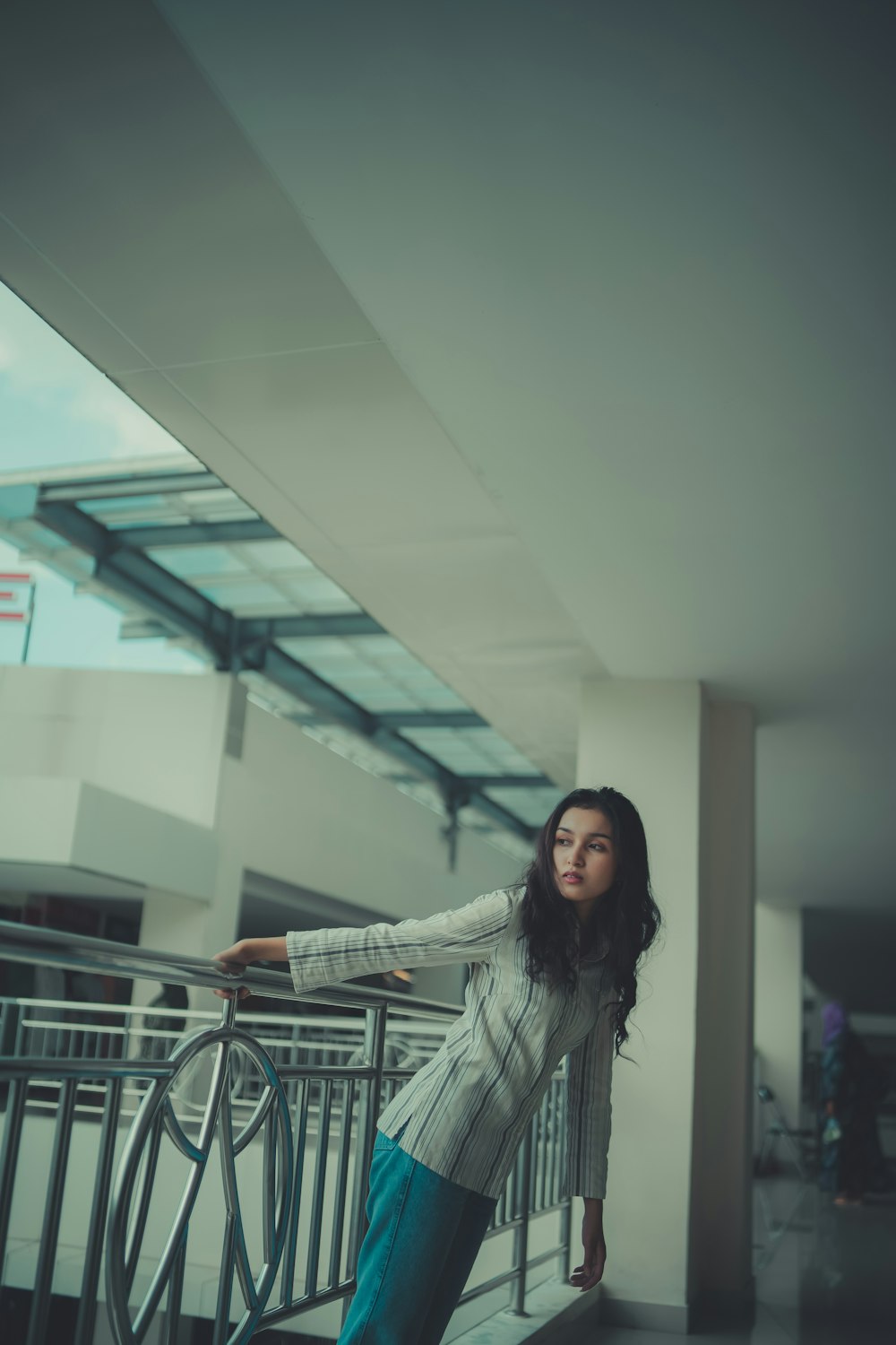 a woman leaning on a railing in a building