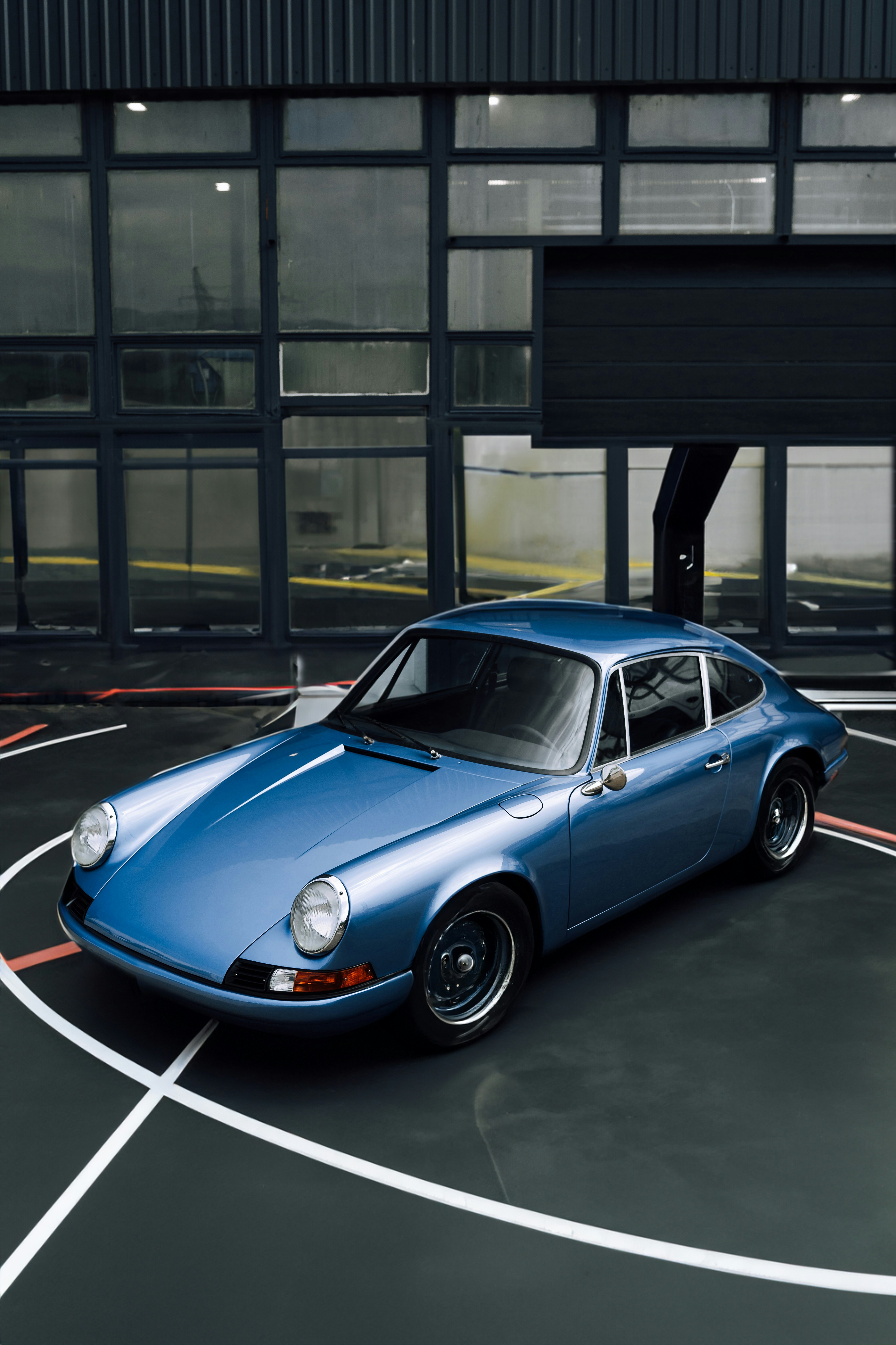 Un coche deportivo azul aparcado en un aparcamiento