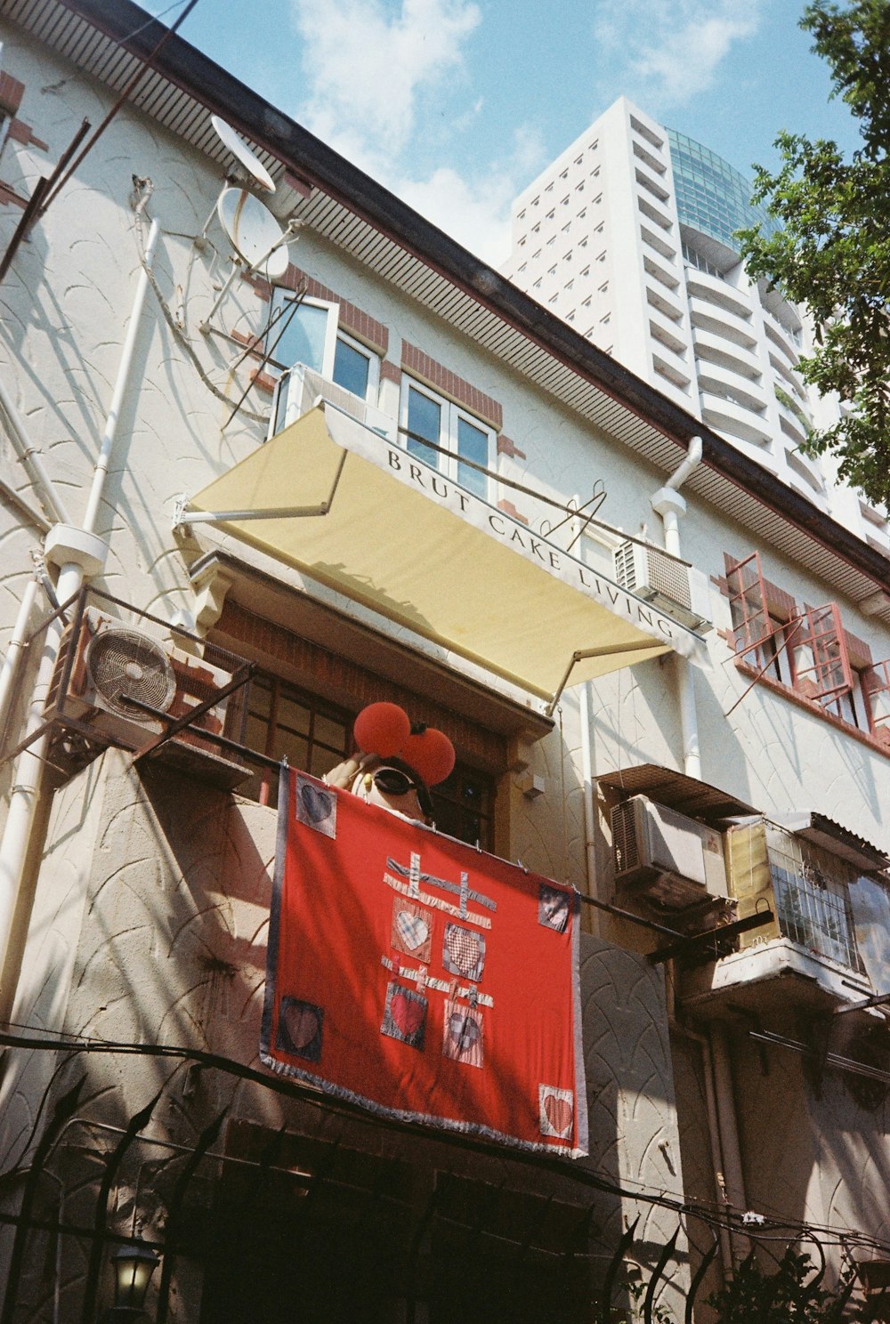 ein Gebäude mit einem roten Schild, das an der Seite hängt