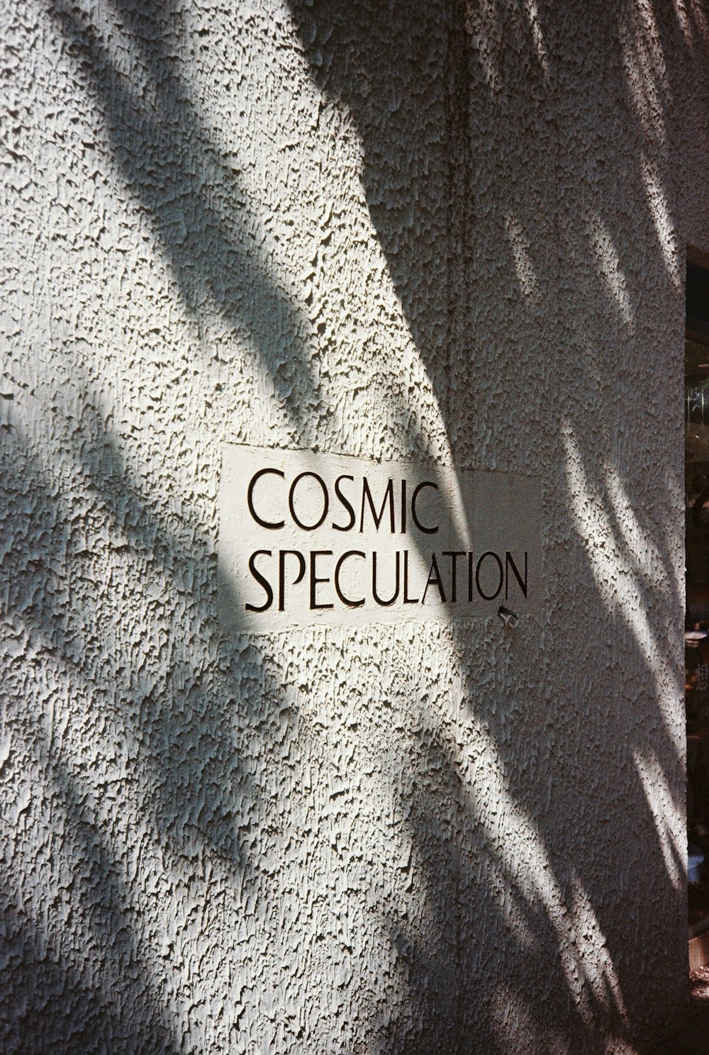 Un cartello sul lato di un edificio che dice Cosmic Specculation