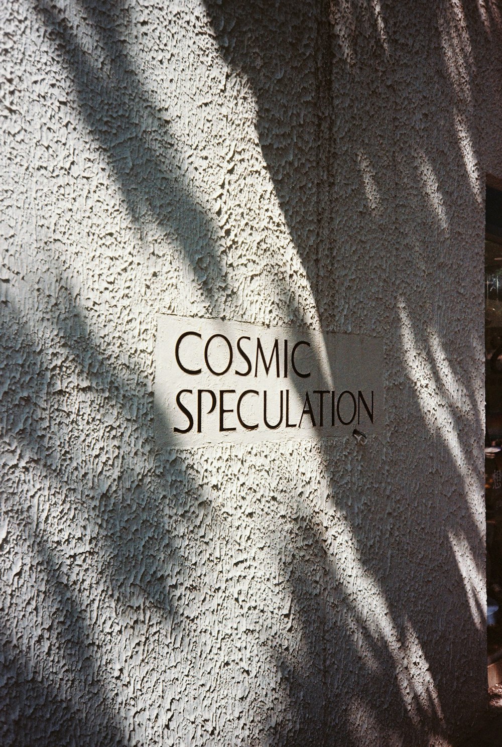 a sign on the side of a building that says cosmic specculation