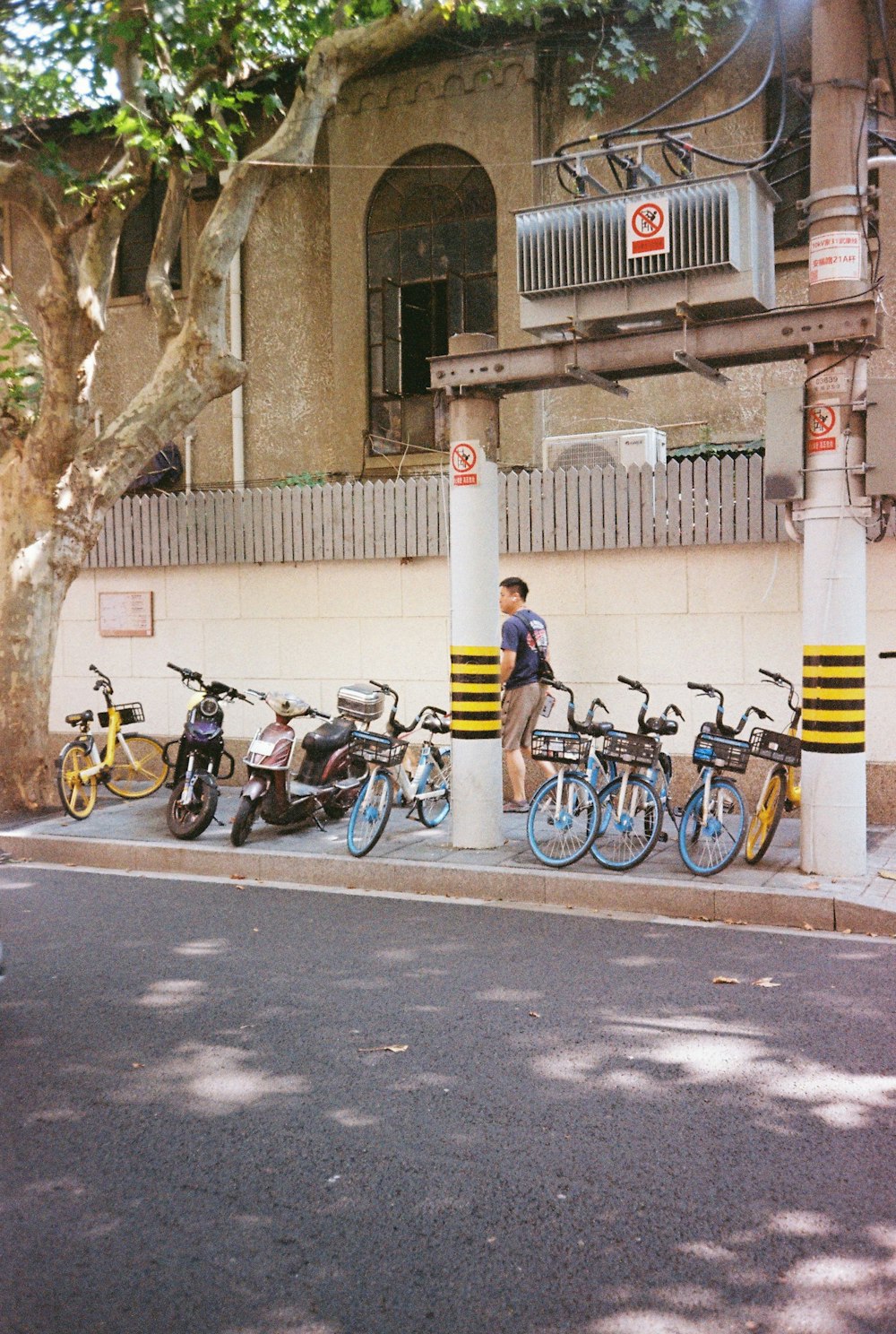 a man standing next to a row of parked bikes