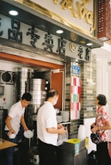 A busy GoFood merchant kitchen with chefs preparing various dishes.