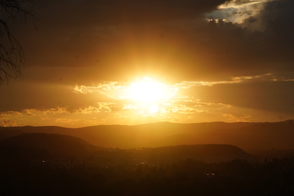 the sun is setting over a mountain range