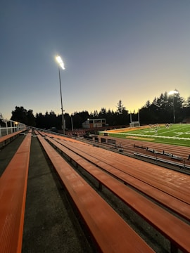 A sports commentator interviewing a focused athlete on the field with bright stadium lights