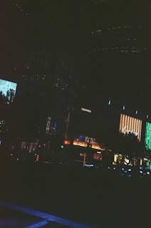 A cinematic frame capturing a quiet moment in an urban night scene with neon reflections.