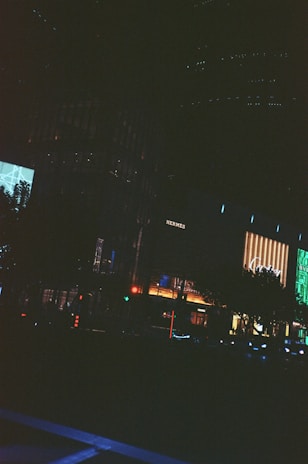 A cinematic frame capturing a quiet moment in an urban night scene with neon reflections.