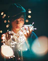 a young boy holding a string of lights