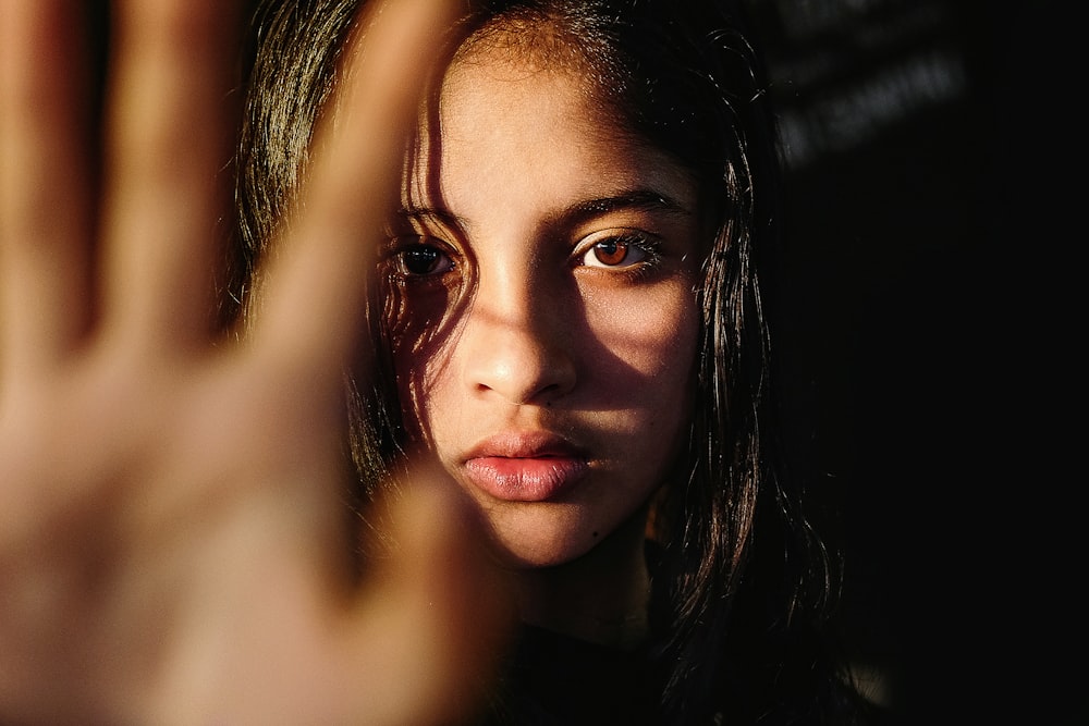 a young woman making a hand gesture with her right hand