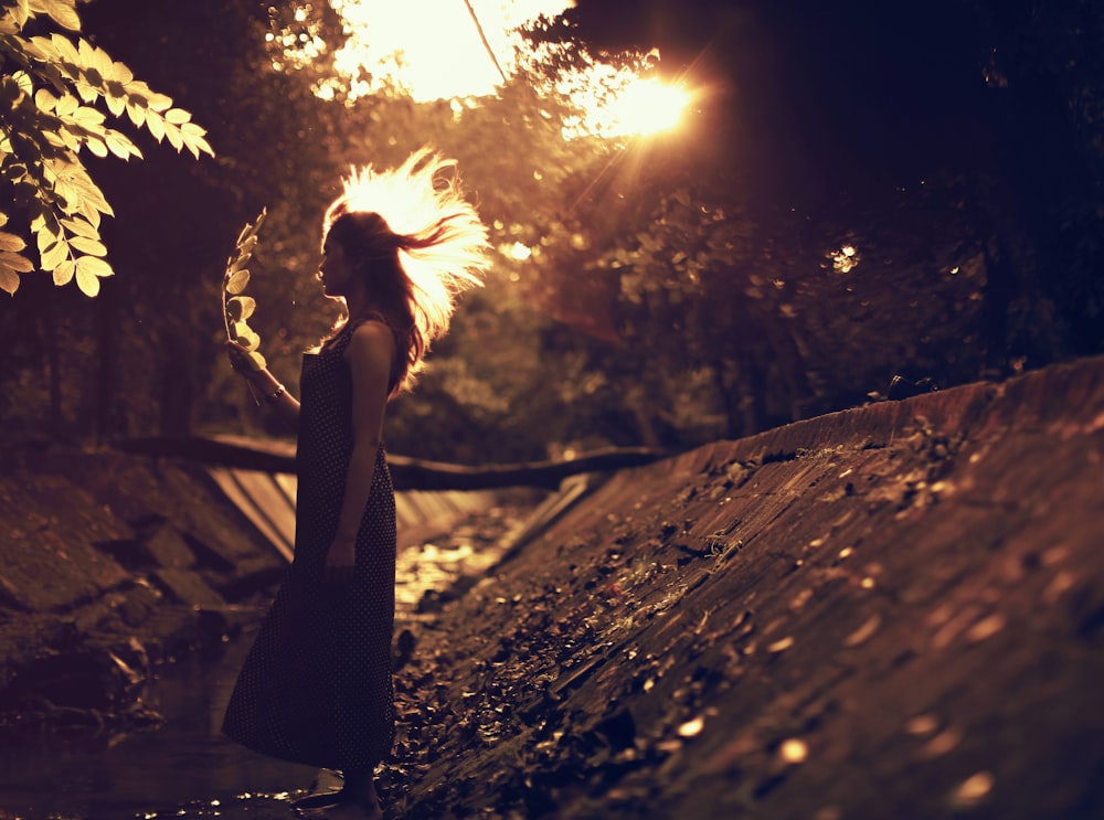 a woman in a dress is standing in the woods