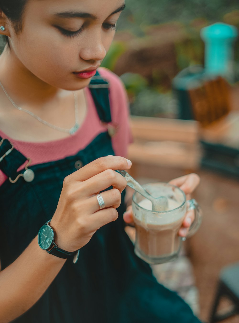 a woman is holding a cup of coffee