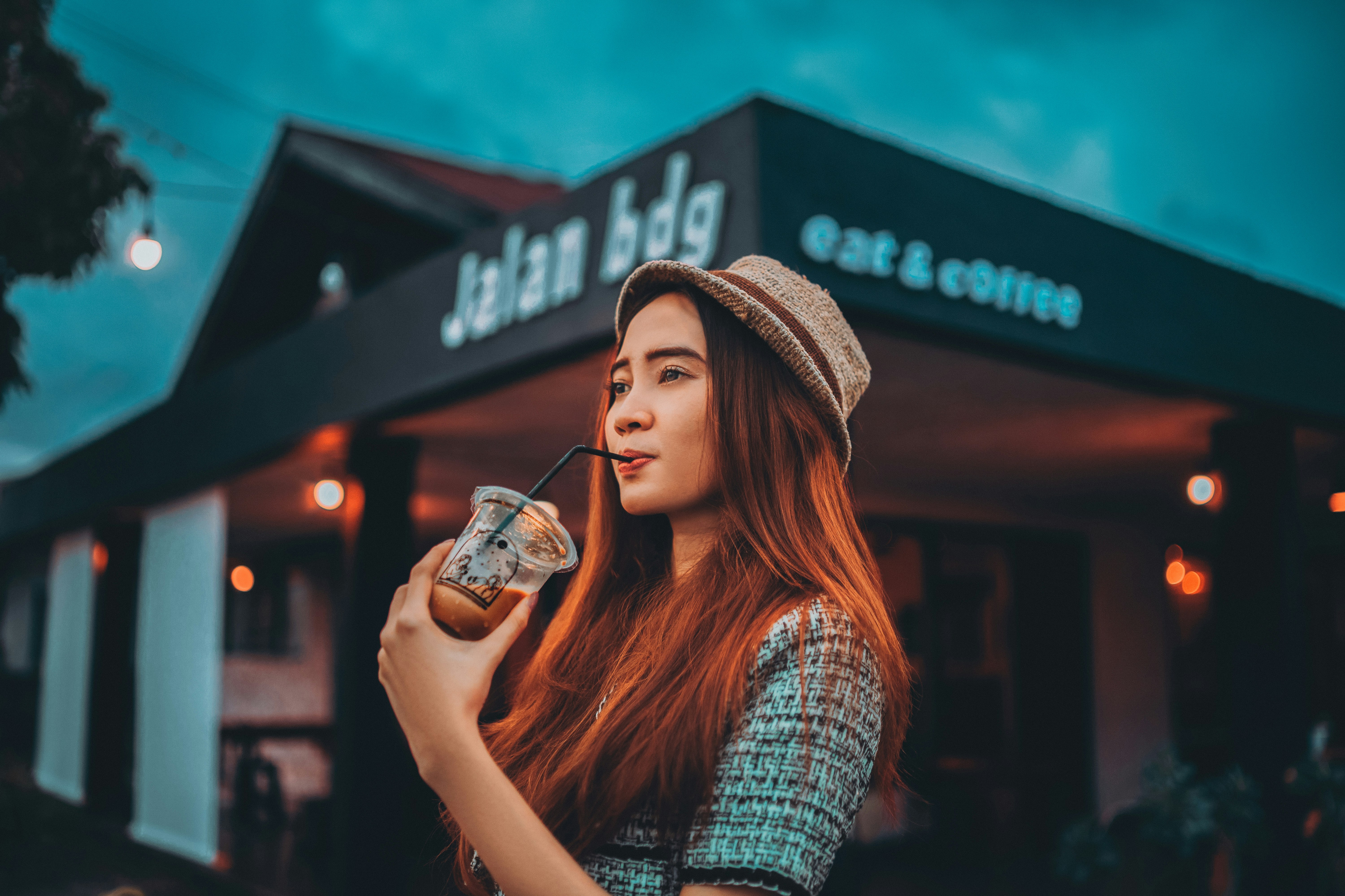 a woman with long red hair is holding a drink