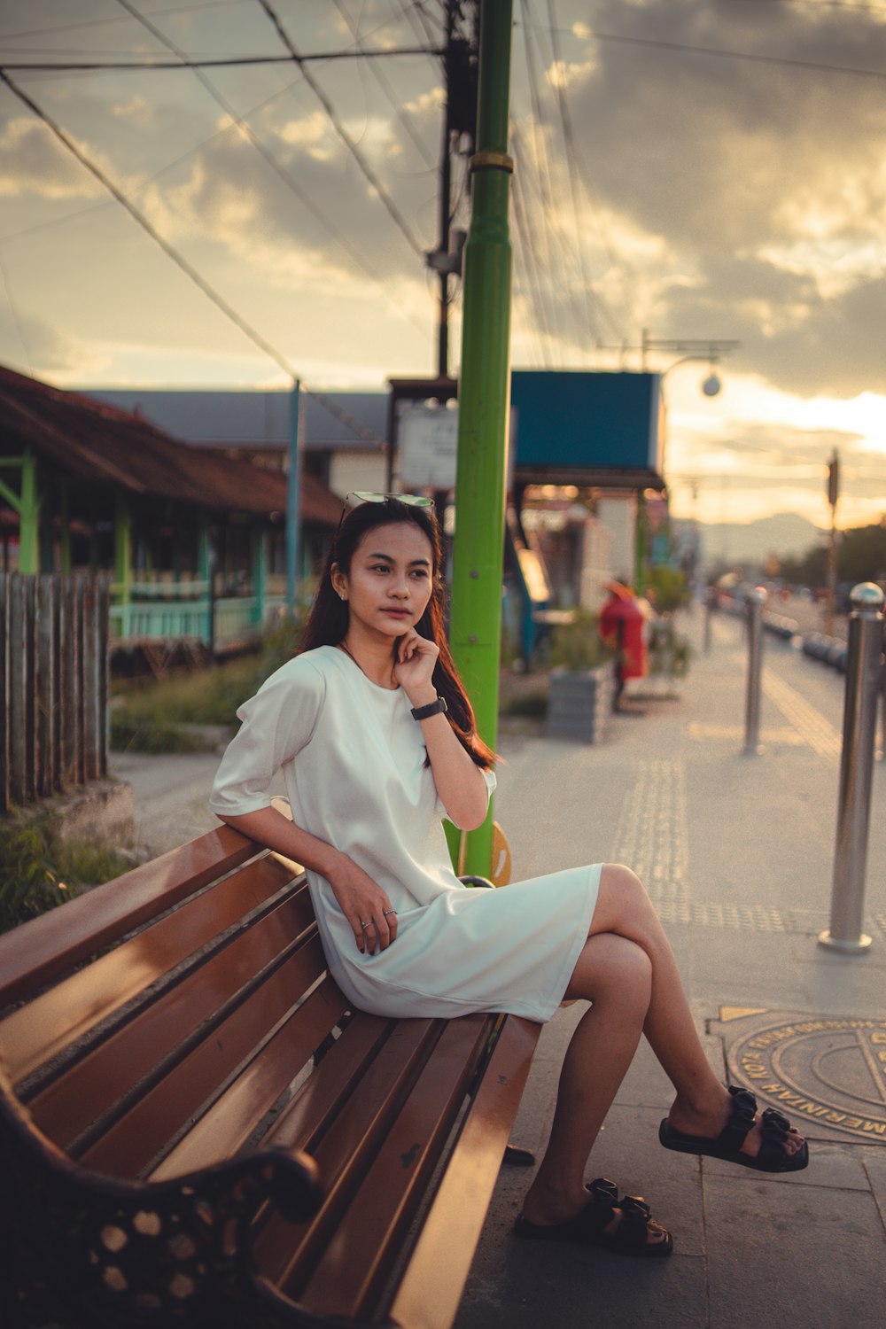 a woman sitting on a bench talking on a cell phone