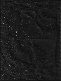 A cosmic-themed layout showcasing sleek black tees with shimmering star patterns under a twilight sky.