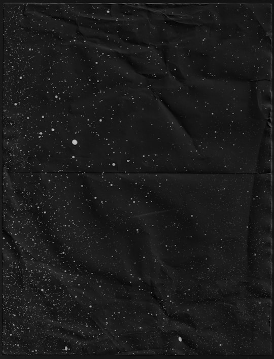 A cosmic-themed layout showcasing sleek black tees with shimmering star patterns under a twilight sky.
