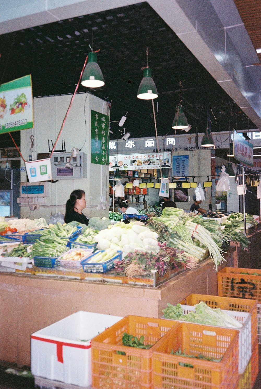 a woman standing in front of a counter filled with vegetables