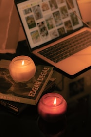 A cozy home setup with a laptop showing a paint party session and colorful art supplies nearby.