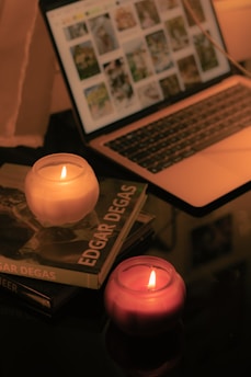 A serene, cozy setting for online therapy with a laptop, notebook, and a candle, evoking comfort and introspection.