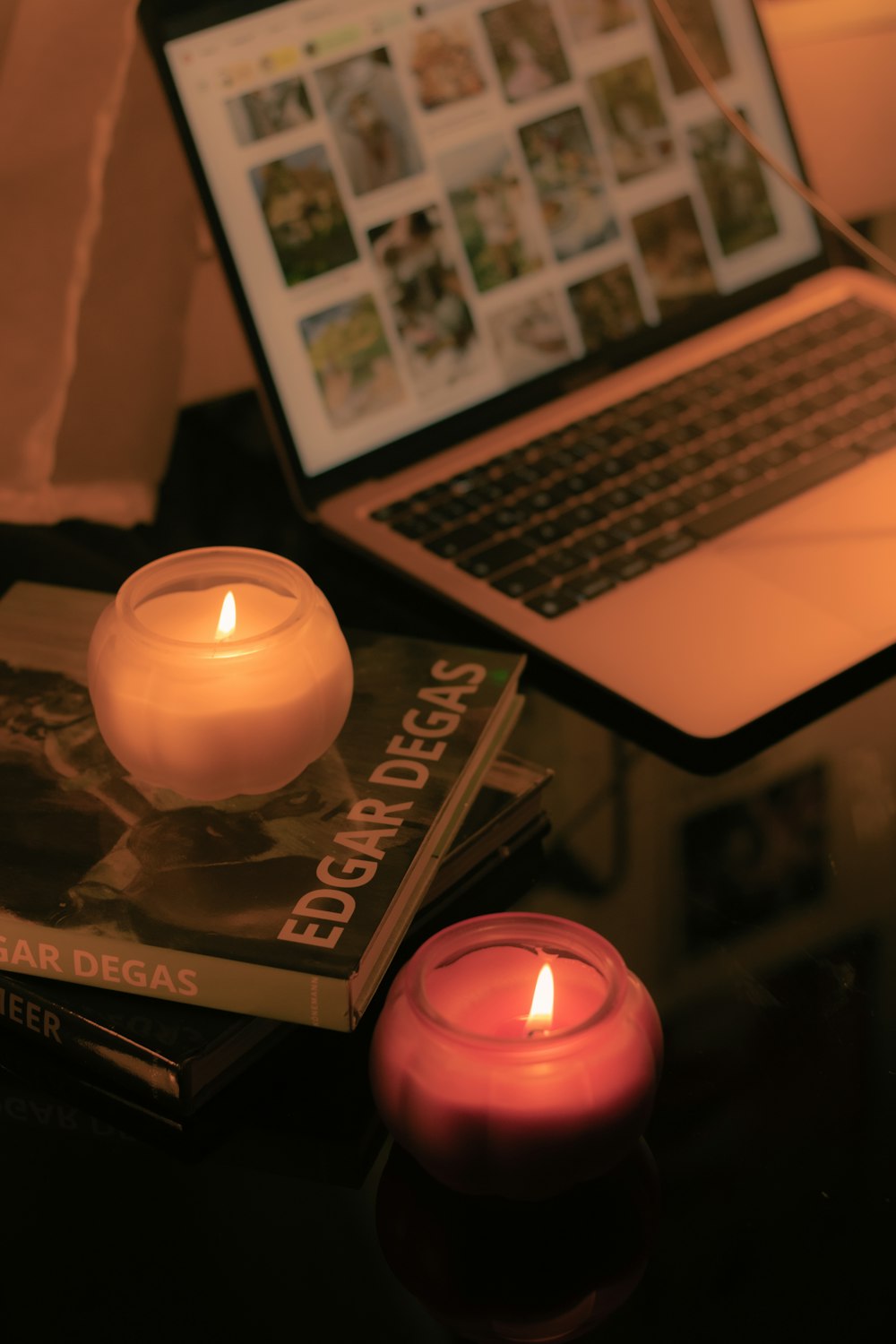 a laptop computer sitting on top of a table next to a candle