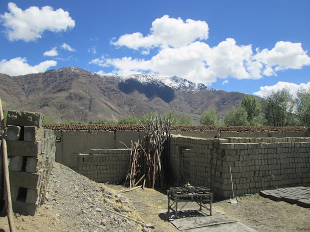 A scenic view of a remote village with a school under construction.
