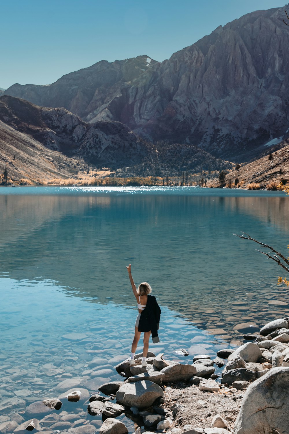 Un niño parado sobre rocas cerca de un cuerpo de agua