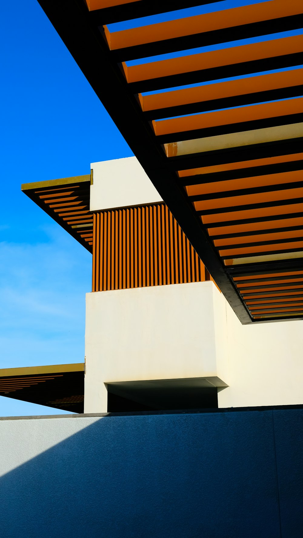 a white building with a wooden roof and a blue sky