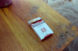 Close-up of a sleek rizz filter tobacco pouch resting on a wooden table with soft natural light.