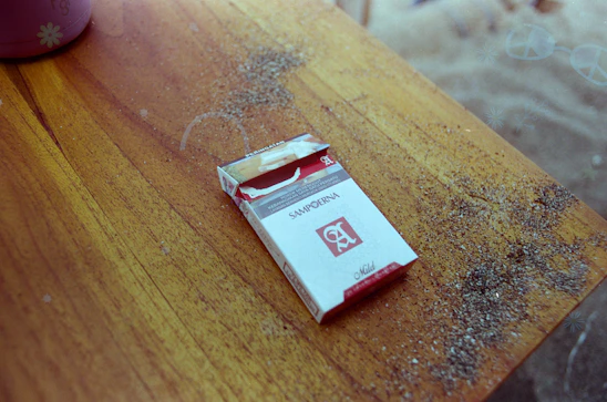 Close-up of a sleek rizz filter tobacco pouch resting on a wooden table with soft natural light.