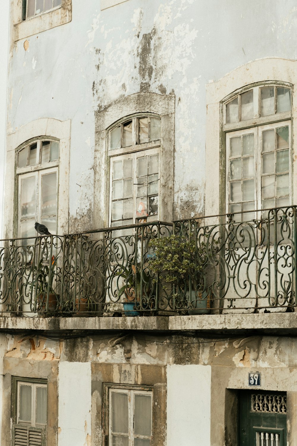 an old building with a balcony and a bird sitting on the balcony