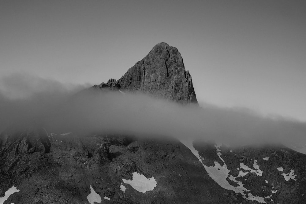 black and white photograph of a mountain covered in clouds