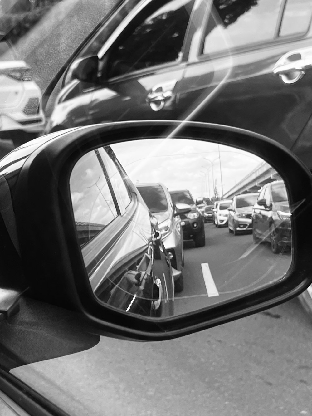 a side view mirror on a car reflecting cars in it