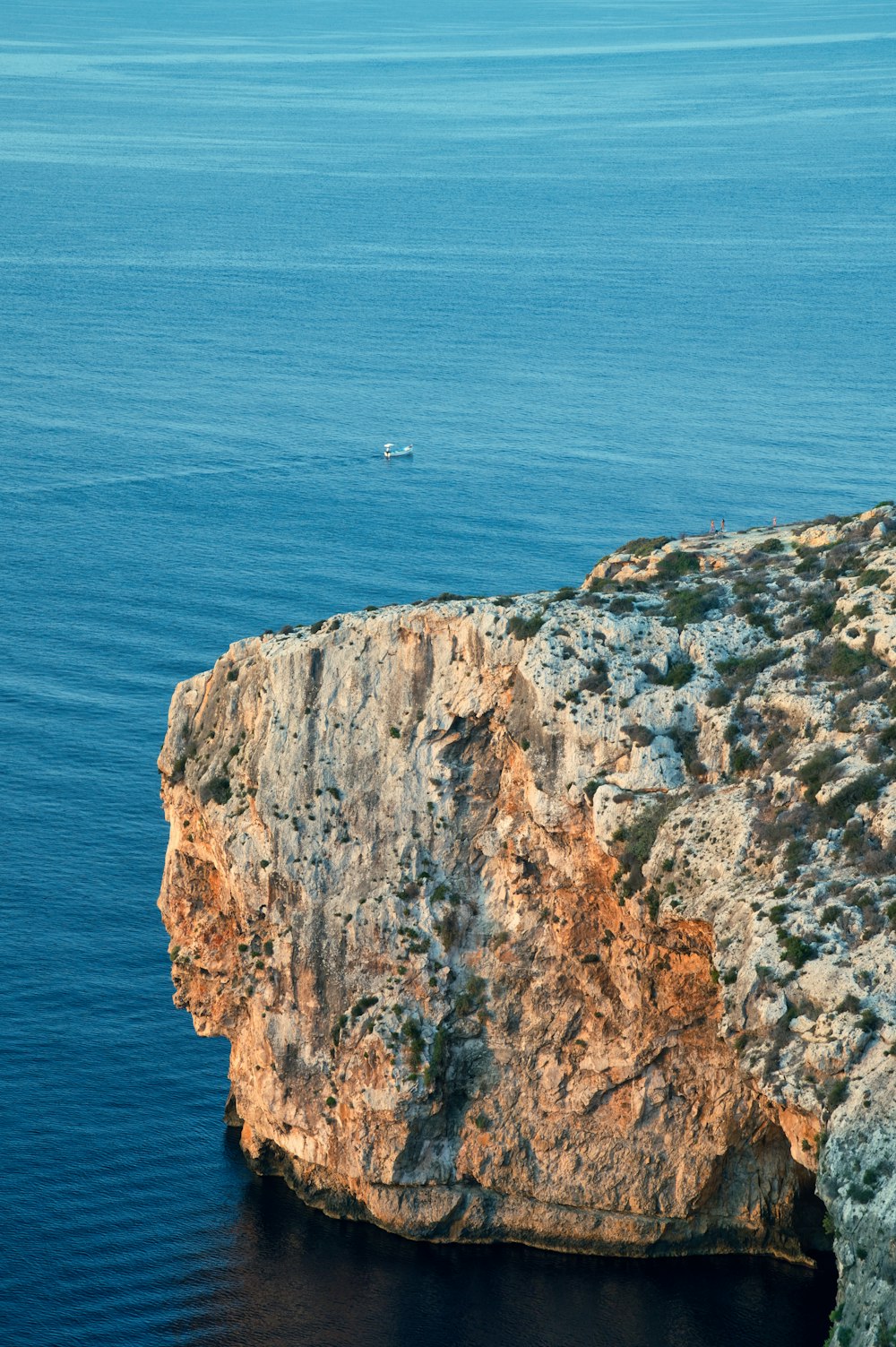 a large rock formation in the middle of a body of water