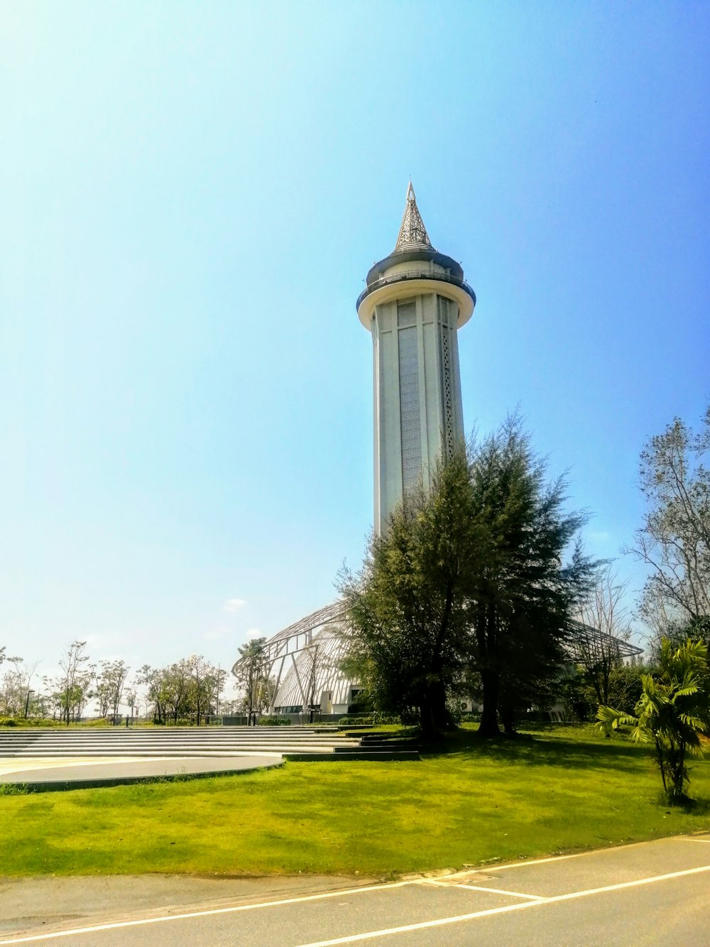 a very tall tower sitting next to a lush green field