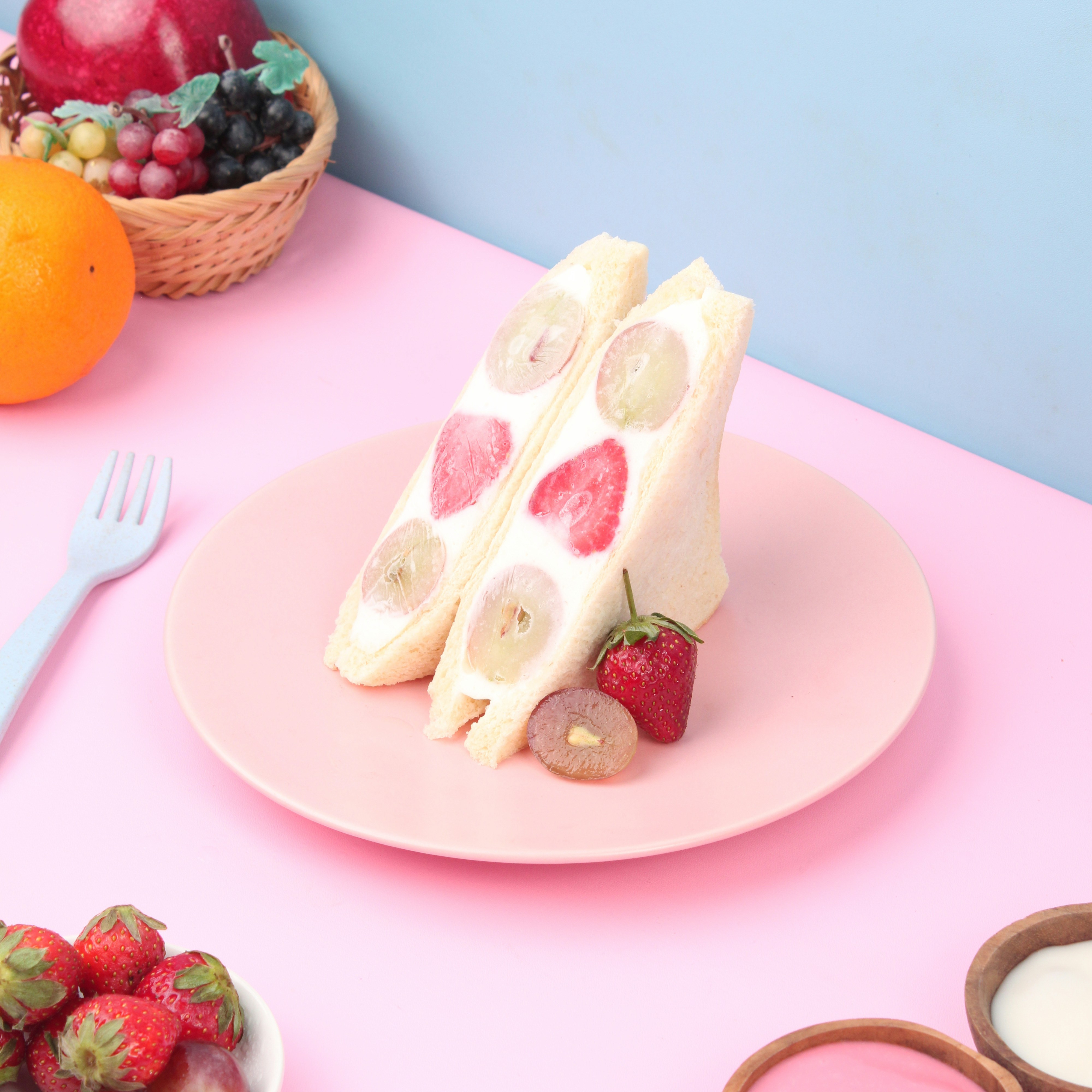 sepotong kue duduk di atas piring merah muda