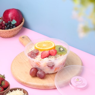 A vibrant fruit salad served in a disposable container.