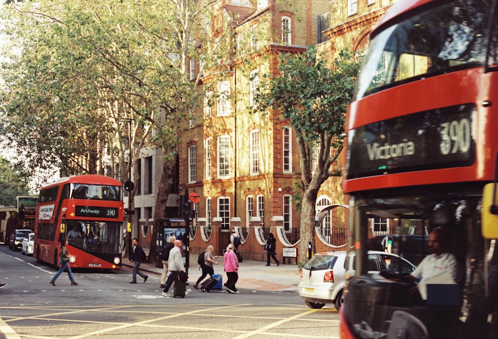 a red double decker bus driving down a street