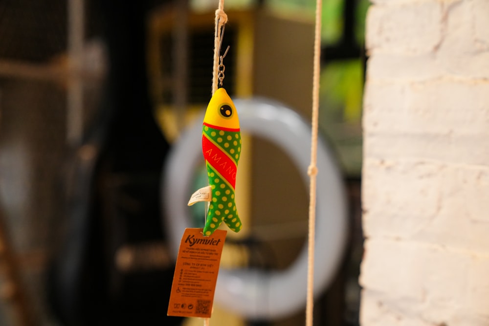 a bird toy hanging from a rope next to a toilet