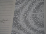 A close-up photograph of a page from a book, likely a religious text, featuring dense printed text on the right side. The left margin contains lined spaces for notes, where a few handwritten words are visible. The text includes a passage with verses speaking about future events and prophecies.