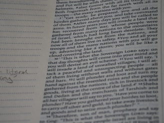 A close-up photograph of a page from a book, likely a religious text, featuring dense printed text on the right side. The left margin contains lined spaces for notes, where a few handwritten words are visible. The text includes a passage with verses speaking about future events and prophecies.