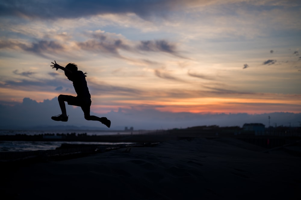 a person jumping in the air at sunset