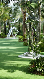 a lush green park filled with lots of palm trees