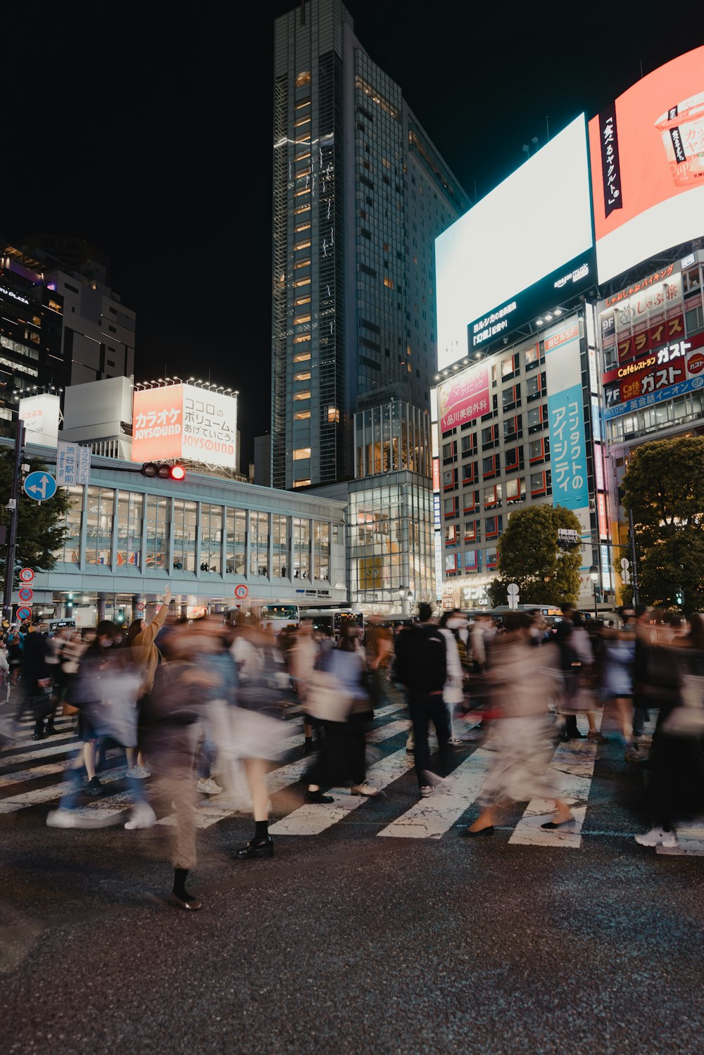 a crowd of people crossing a street at night